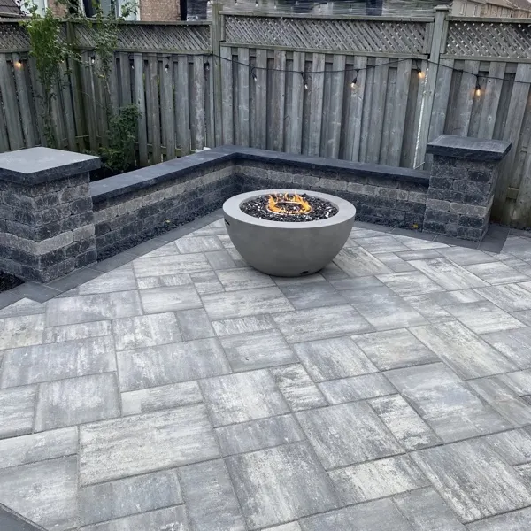 Backyard interlocking patio with a fire pit bowl and block seat wall, Guelph landscaping by BCI Landscaping