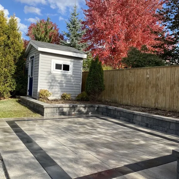 Interlock block retaining wall with an interlocking paver patio in a Guelph backyard